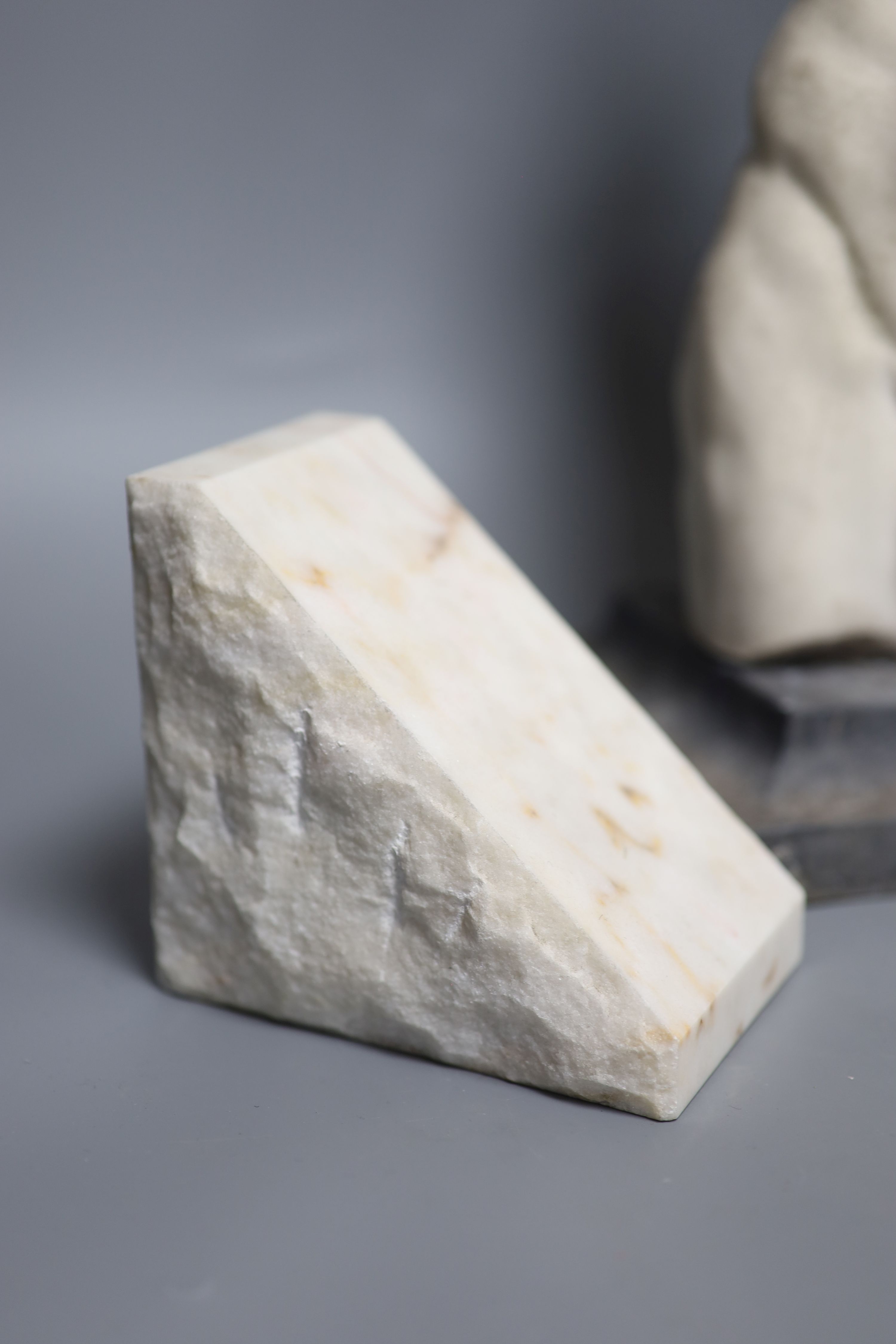 A resin bust of a classical torso on stand and a pair of alabaster bookends